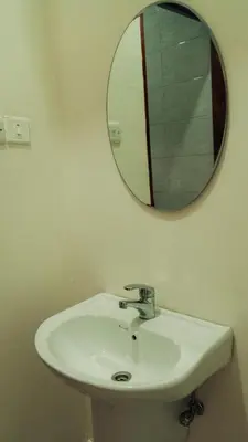 a bathroom with a white sink and a mirror at Hatua Dahlia Home in Arusha