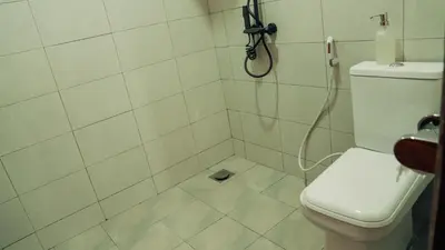 a bathroom with a shower with a toilet at Hatua Dahlia Home in Arusha