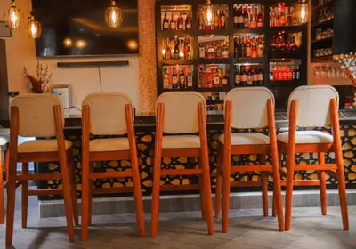 a group of chairs sitting at a bar at River House Lodge International in Arusha