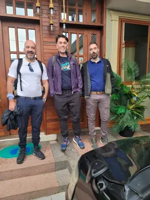 a group of three men standing in front of a building at River House Lodge International in Arusha