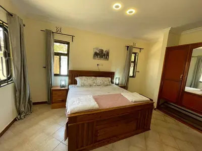a bedroom with a large bed in a room at Emmalanta Safaris House in Arusha