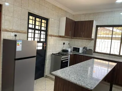 a kitchen with a white refrigerator and a counter top at Emmalanta Safaris House in Arusha