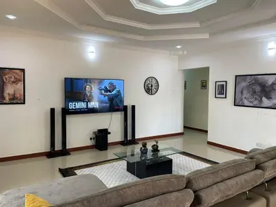 a living room with a couch and a flat screen tv at Emmalanta Safaris House in Arusha