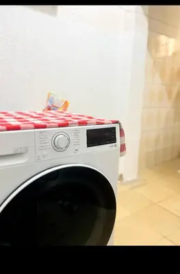 a white washing machine with a red and white at Divine Homestay Arusha in Arusha