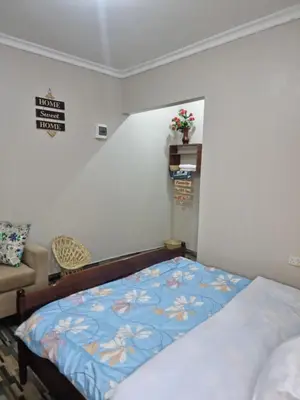 a bedroom with a bed and a couch at Divine Homestay Arusha in Arusha