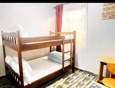 a wooden bunk bed in a room with a window at Divine Homestay Arusha in Arusha