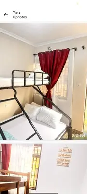two bunk beds in a room with a window at Divine Homestay Arusha in Arusha