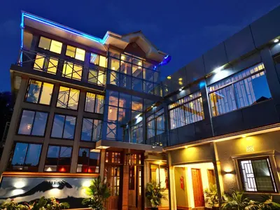 a large building with a lot of windows at night at River House Lodge in Arusha