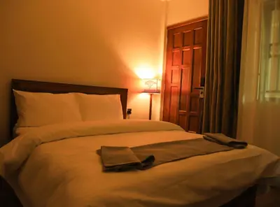 a bedroom with a bed with a robe on it at River House Lodge in Arusha
