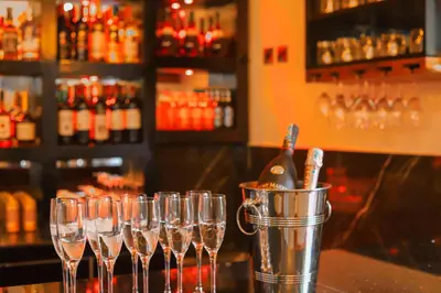 a group of wine glasses on a bar with a bucket at River House Lodge in Arusha