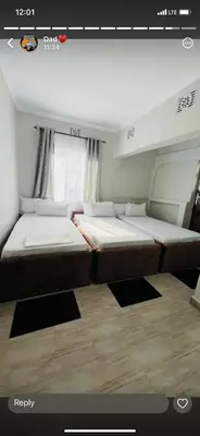 two beds in a small room with a window at Jackpot BnB in Arusha