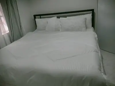 a white bed with white sheets and pillows at Jackpot BnB in Arusha