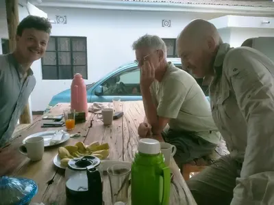 a group of three men sitting around a table at Jackpot BnB in Arusha