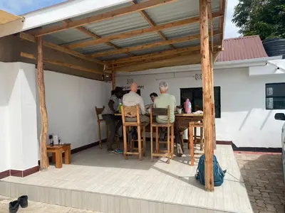 a group of people sitting at a table on a patio at Jackpot BnB in Arusha