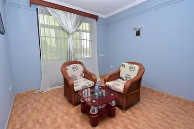two chairs and a table in a room with a window at Acres Hotels in Arusha