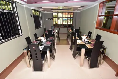a dining room with black tables and chairs at Acres Hotels in Arusha