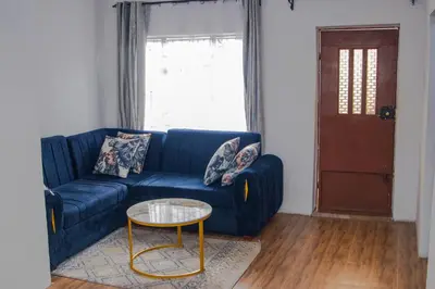 a blue couch in a living room with a table at Osim Apartment in Arusha