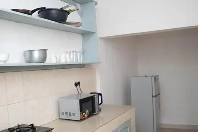 a kitchen with a microwave on a counter with a refrigerator at Osim Apartment in Arusha