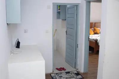 a room with a door open to a bedroom at Osim Apartment in Arusha