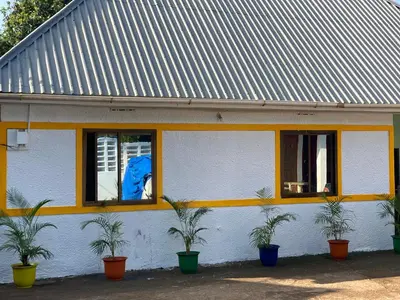 a building with two windows with plants in front of it at Tourist Home in Moshi