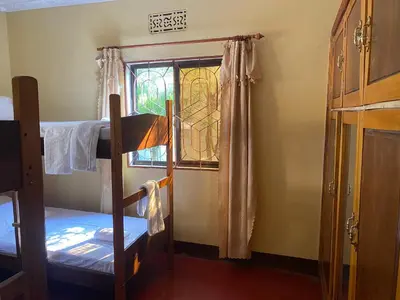 a bedroom with a bunk bed and a window at Tourist Home in Moshi