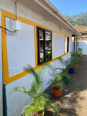 a building with a bunch of plants in front of it at Tourist Home in Moshi