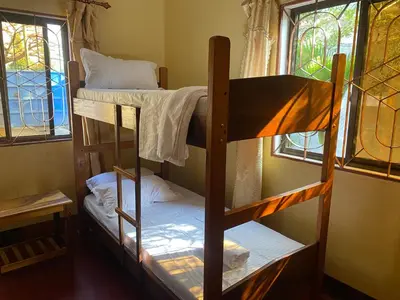 two bunk beds in a room with two windows at Tourist Home in Moshi