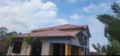 a house with a tiled roof on top of it at Lambatini Homestays & Lodges in Arusha