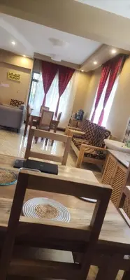 a large room with wooden tables and chairs at Lambatini Homestays & Lodges in Arusha