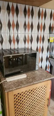 a microwave sitting on top of a counter in a kitchen at Lambatini Homestays & Lodges in Arusha
