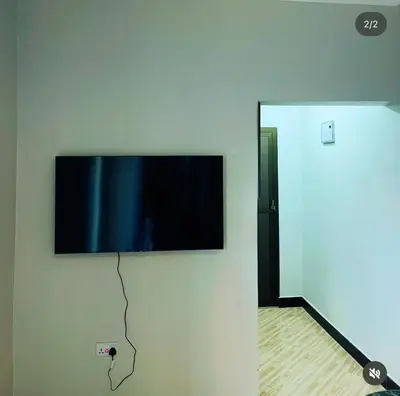 a flat screen tv hanging on a wall at Kanyigo homes Apartments in Arusha