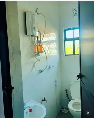 a bathroom with a toilet and a sink at Kanyigo homes Apartments in Arusha