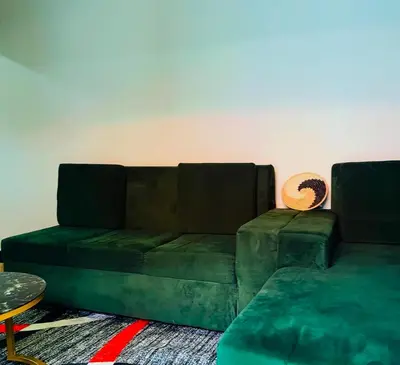 a green couch sitting in a living room at Kanyigo homes Apartments in Arusha