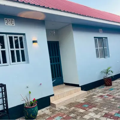 a blue and white house with a red roof at Kanyigo homes Apartments in Arusha