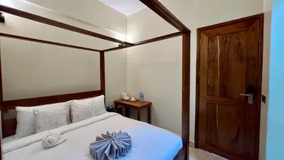 a bedroom with a large bed with a wooden frame at Skylark Hotel in Karatu
