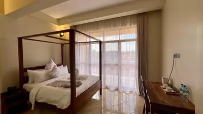 a bedroom with a canopy bed and a large window at Skylark Hotel in Karatu