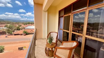 a balcony with two chairs and a view of a street at Skylark Hotel in Karatu