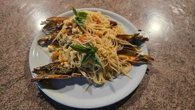 a plate of food with noodles on a table at Arusha Centre Rooms in Arusha