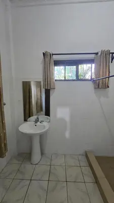 a bathroom with a sink and a window at Arusha Centre Rooms in Arusha