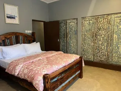 a bedroom with a bed and some windows with curtains at Moshi Urban Hostel and Backpackers in Moshi