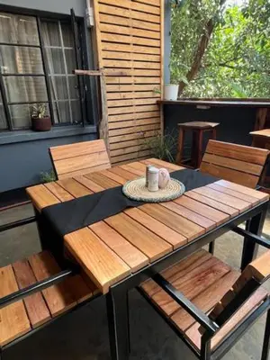 a wooden table with a cup on top of it at Moshi Urban Hostel and Backpackers in Moshi