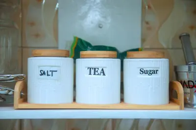 four white mugs on a shelf in a kitchen at Ngorongoro Gateway Homestay in Karatu