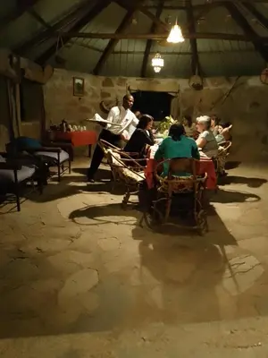 a group of people sitting at tables in a room at Tindiga Tented Camp Eyasi in Mangola