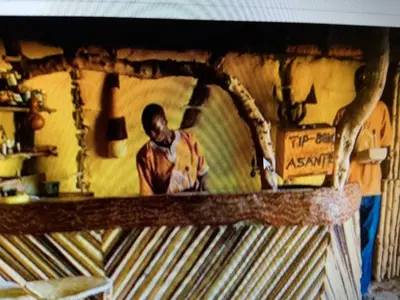 a man standing behind a counter in a kitchen at Tindiga Tented Camp Eyasi in Mangola