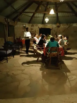 a group of people sitting at tables in a room at Tindiga Tented Camp Eyasi in Mangola