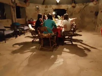 a group of people sitting at a table in a room at Tindiga Tented Camp Eyasi in Mangola