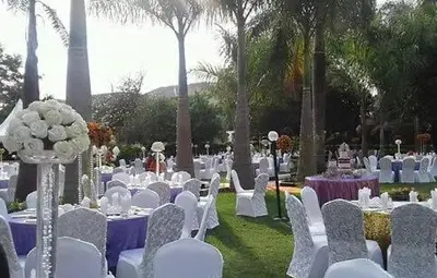 a row of tables and chairs with white chairs and tablesearcher at Njiro Ebenezer Retreat Lodge in Arusha