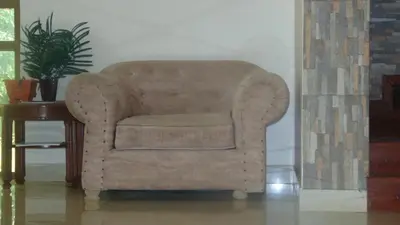 a brown chair sitting next to a table at Njiro Ebenezer Retreat Lodge in Arusha