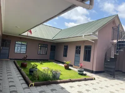 a pink house with a green roof at Kishongo house in Arusha