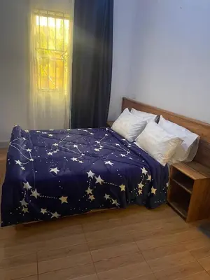 a bed with a blue blanket with stars on it at Kishongo house in Arusha